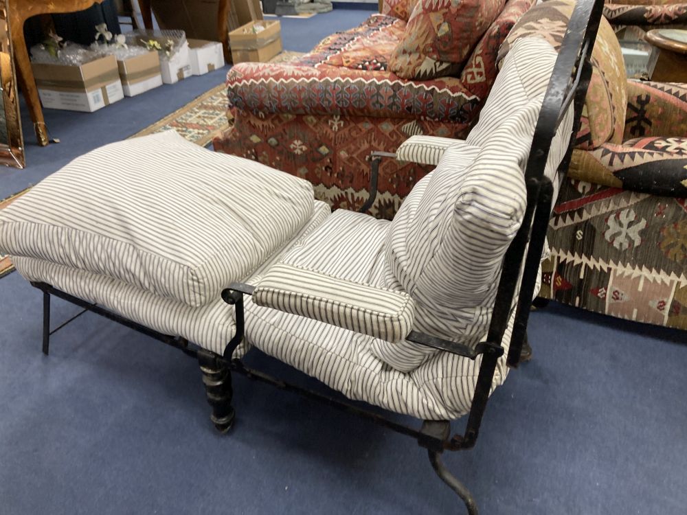 A Victorian wrought iron folding armchair with loose cushion seat and back